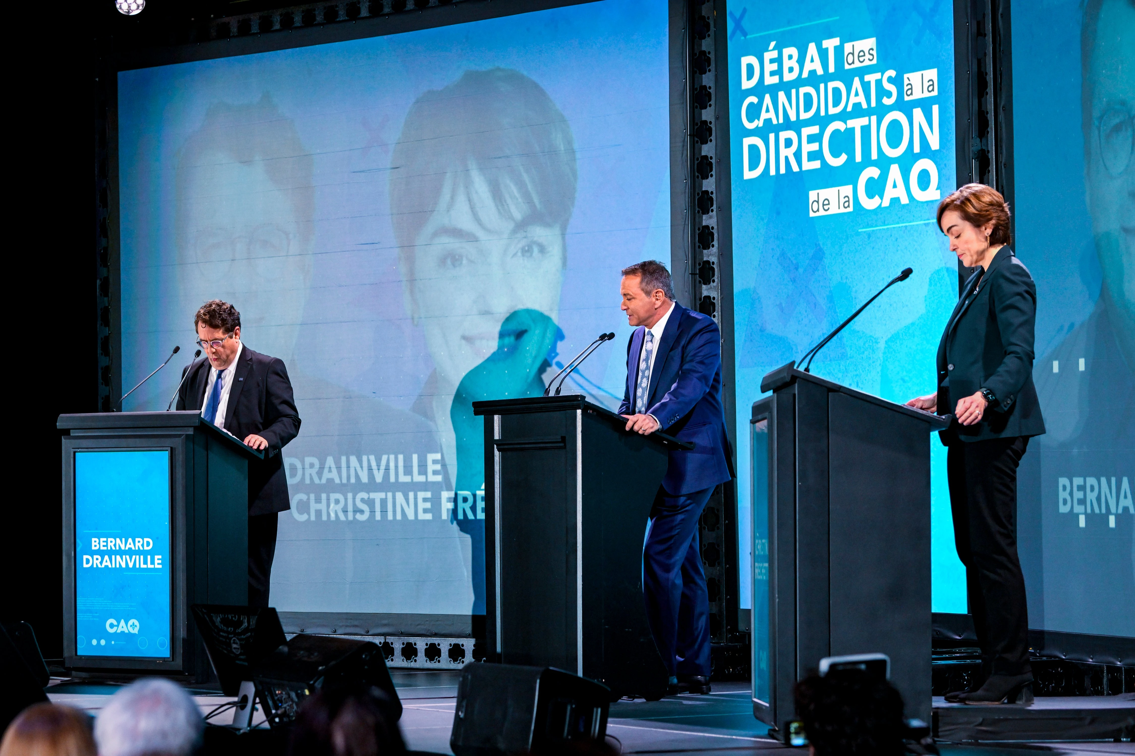 Pierre Jobin modérant le débat de la CAQ — trois podiums