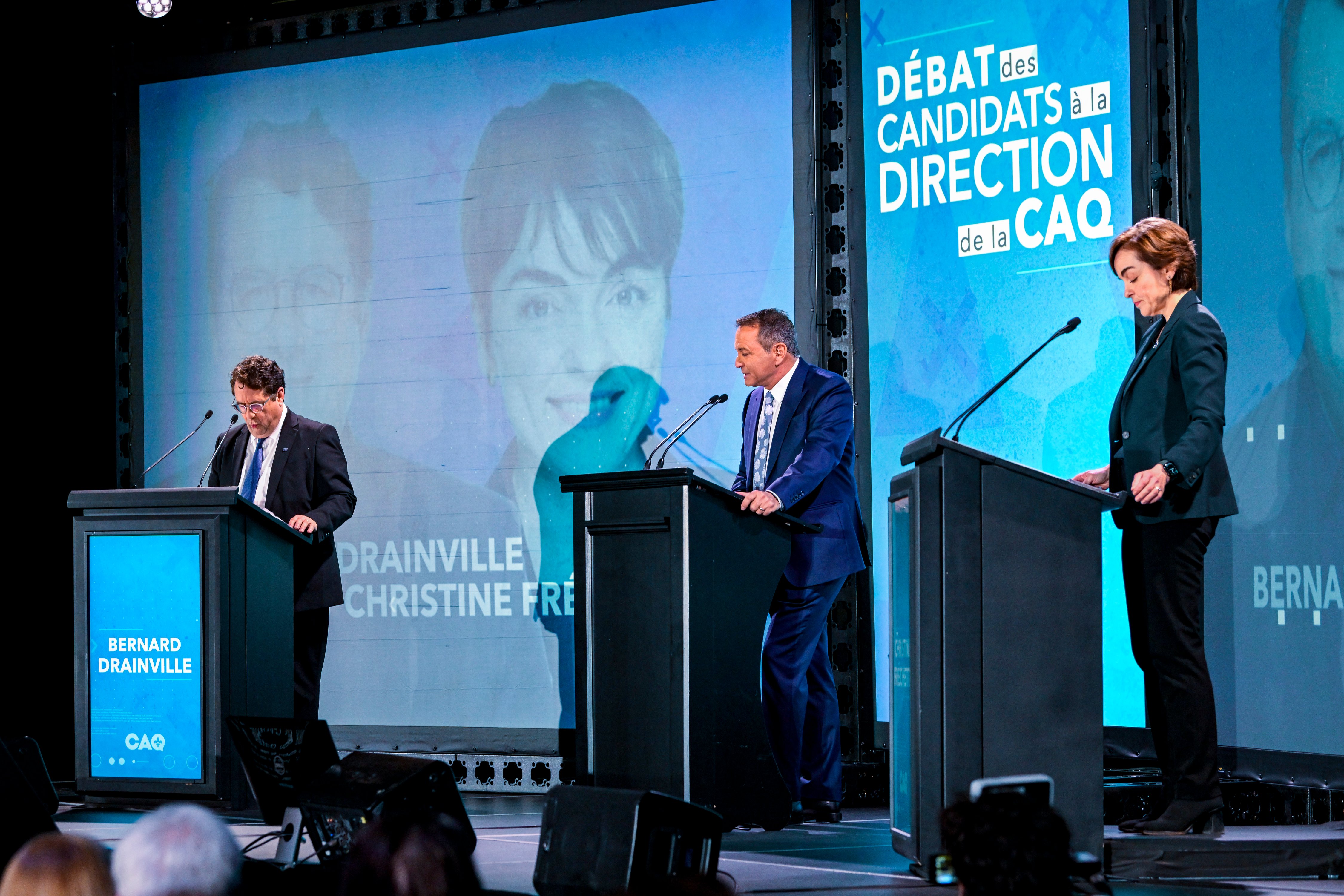 Pierre Jobin modérant le débat de la CAQ — trois podiums